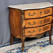 Louis XV style commode with rosewood veneer, gilded bronze mounts, and marble top.