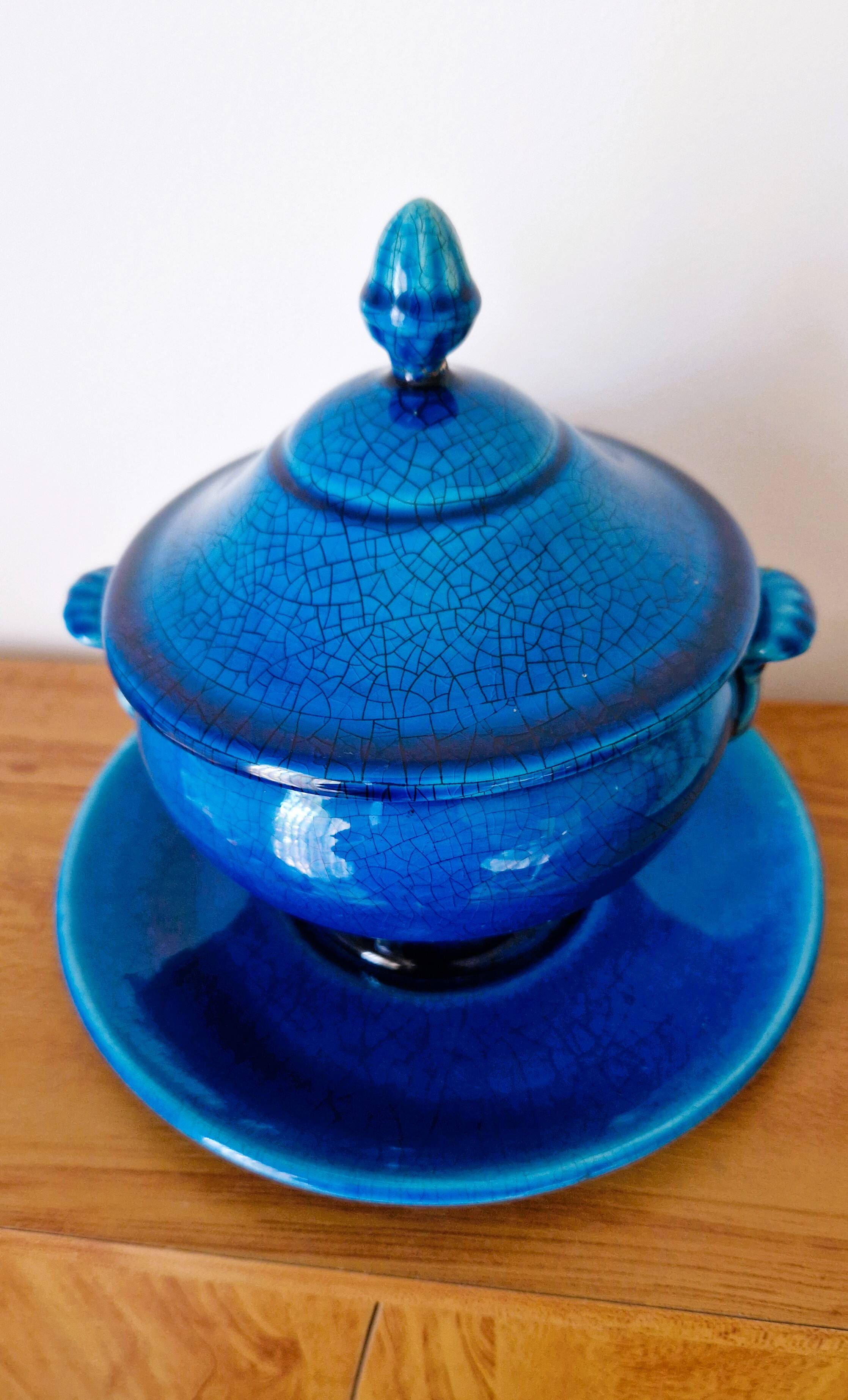 Blue ceramic soup tureen and crackled finish trivet.