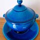 Blue ceramic soup tureen and crackled finish trivet.