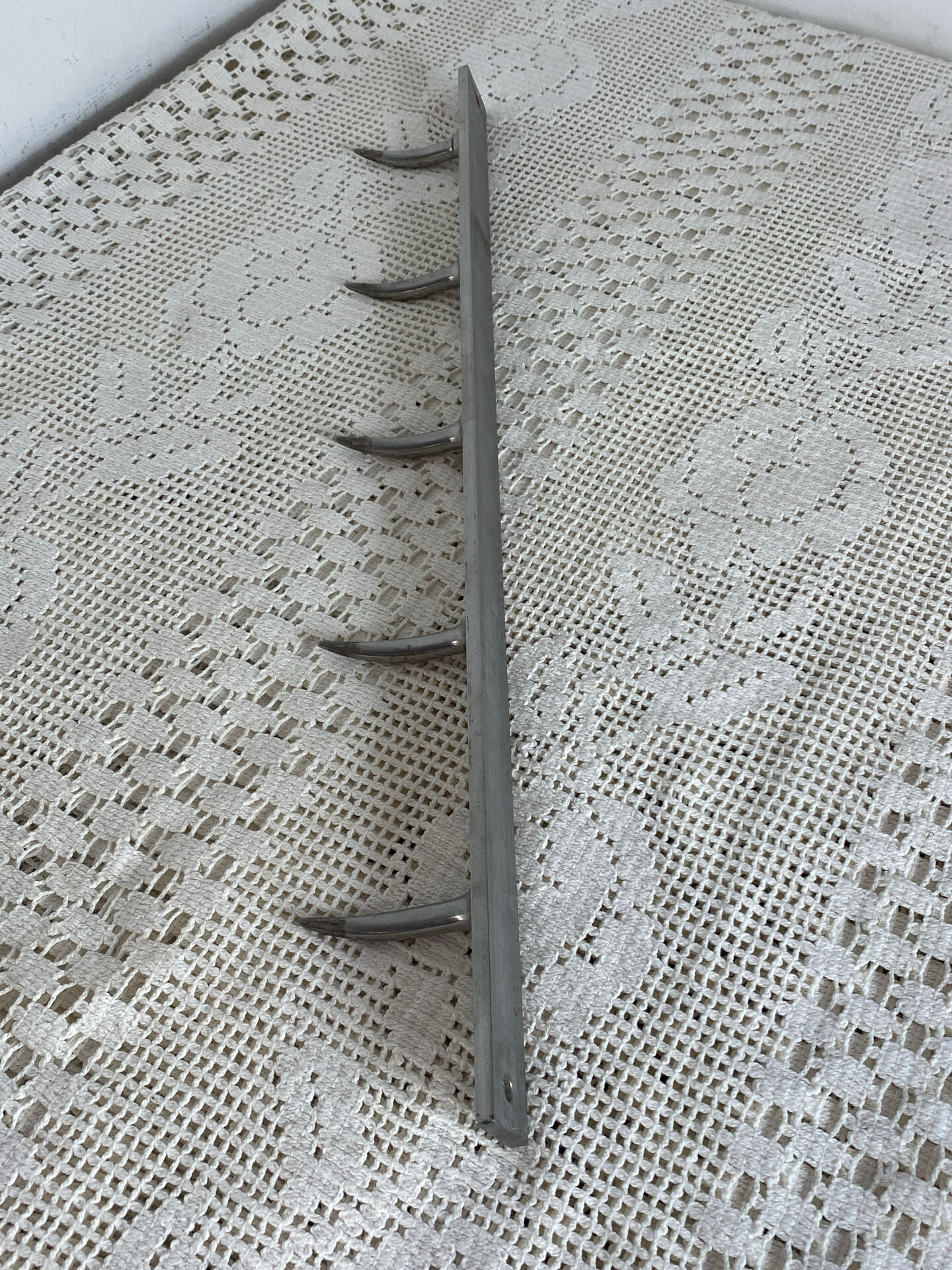 Stainless steel butcher's hook, known as a "wolf tooth bar."
