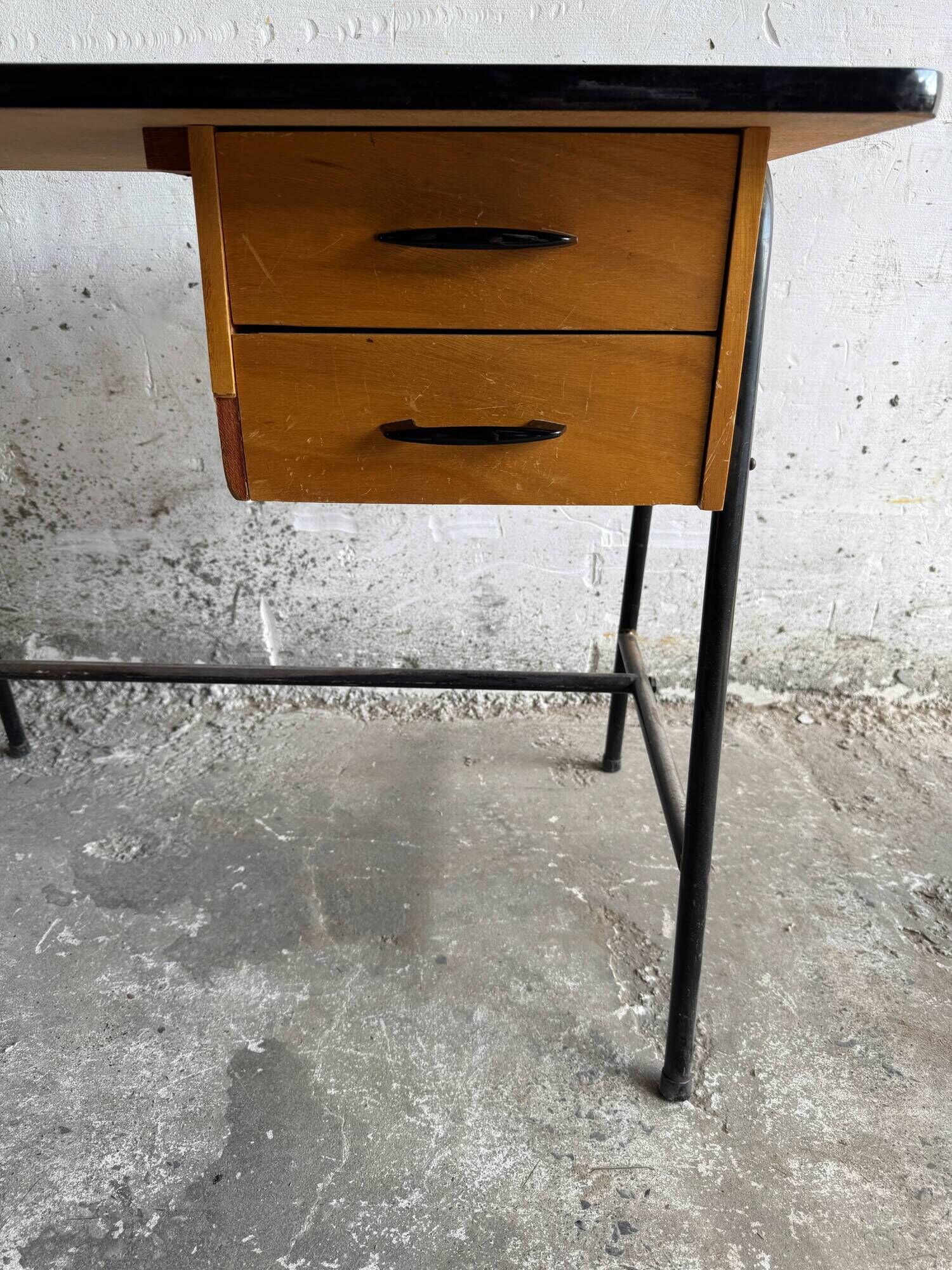 Black metal and wood mid-century industrial desk with laminated top and two drawers