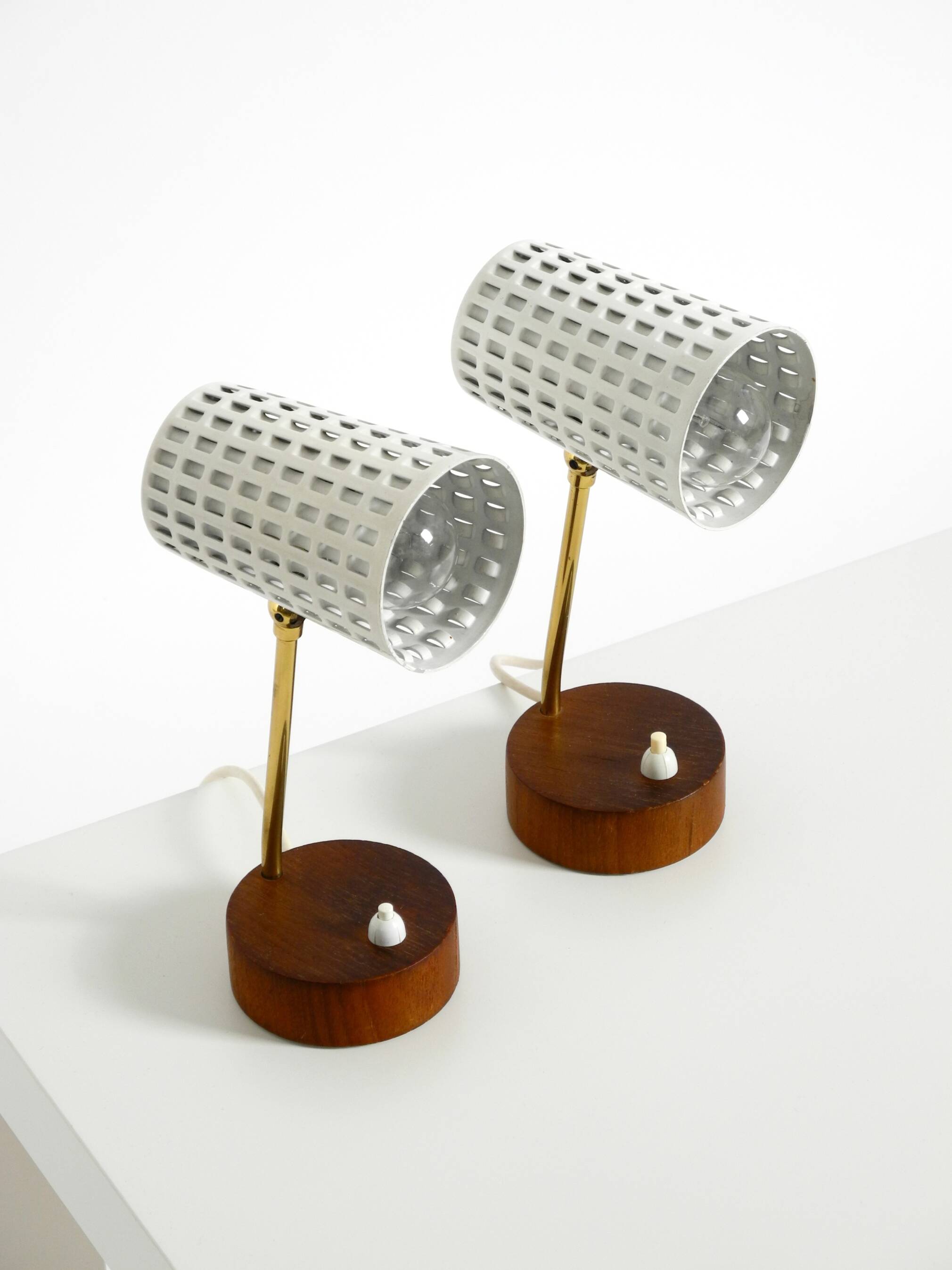 A pair of mid-century modern bedside lamps with perforated metal shades