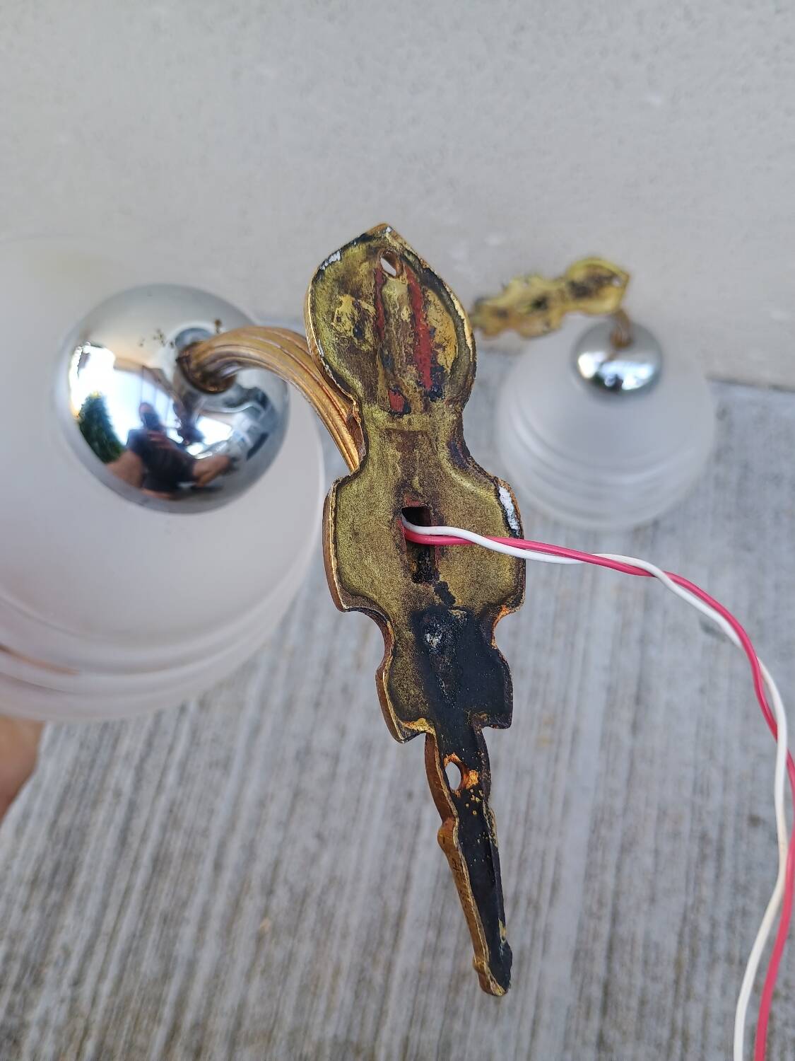 Pair of frosted glass wall lights with brass attachments, circa 1970