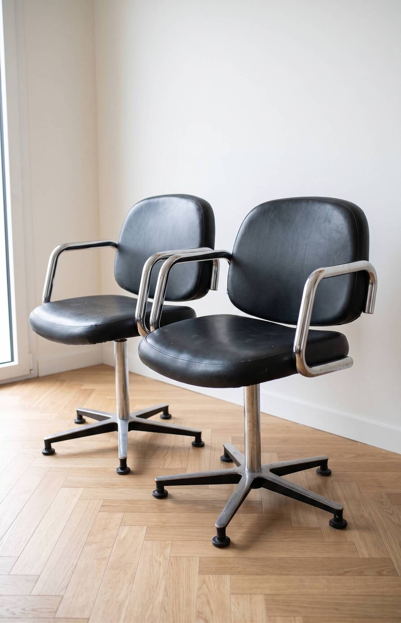 Pair of vintage swivel armchairs in metal and black faux leather.