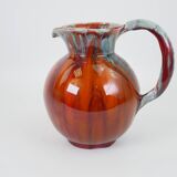 Large red and blue glazed ceramic pitcher signed Delène under the base