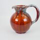 Large red and blue glazed ceramic pitcher signed Delène under the base