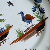 Hand-painted earthenware plate with landscape and bird decoration.