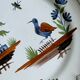 Hand-painted earthenware plate with landscape and bird decoration.