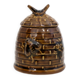 Honey pot in the shape of a hive decorated with bees.