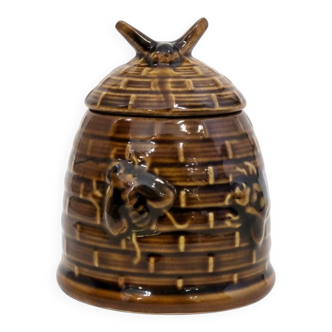 Honey pot in the shape of a hive decorated with bees.