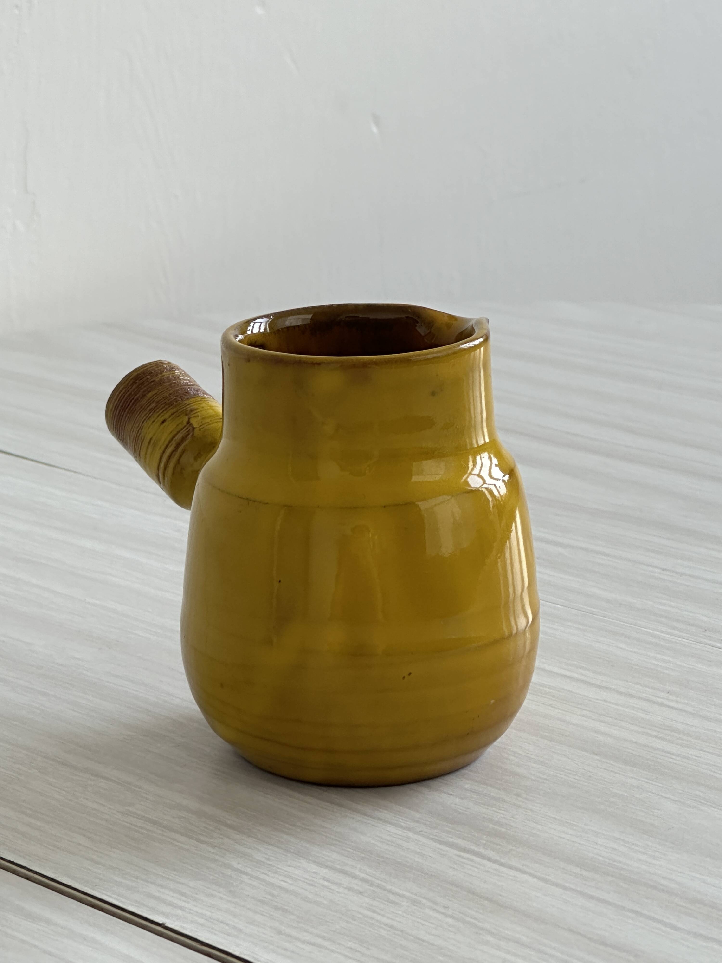 Yellow glazed ceramic sauce boat or milk jug