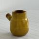 Yellow glazed ceramic sauce boat or milk jug