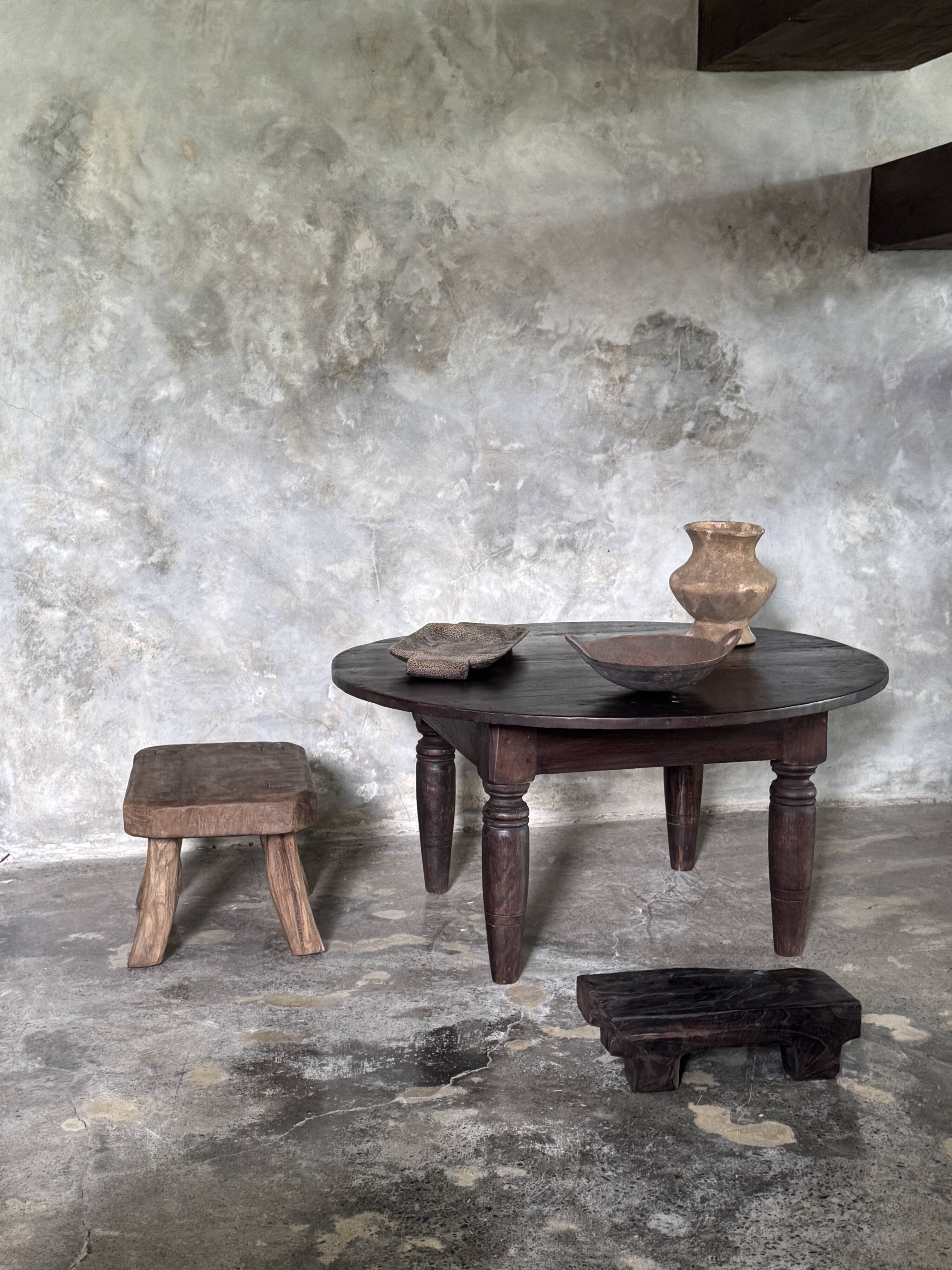 Antique round coffee table in Indonesian teak with turned legs.