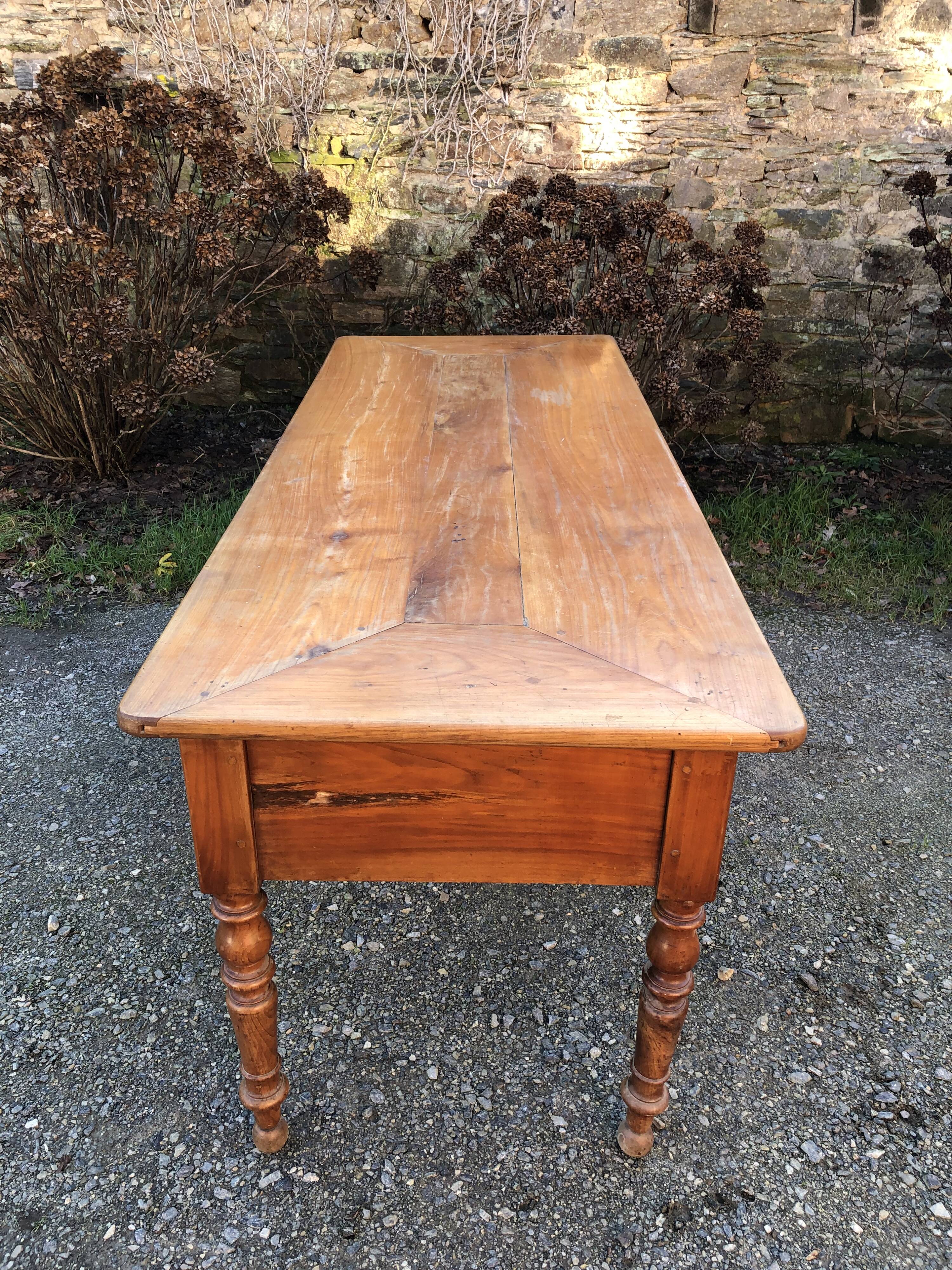 Antique cherry farmhouse table with turned legs and 2 drawers.