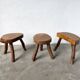 Set of three rustic solid wood tripod stools.