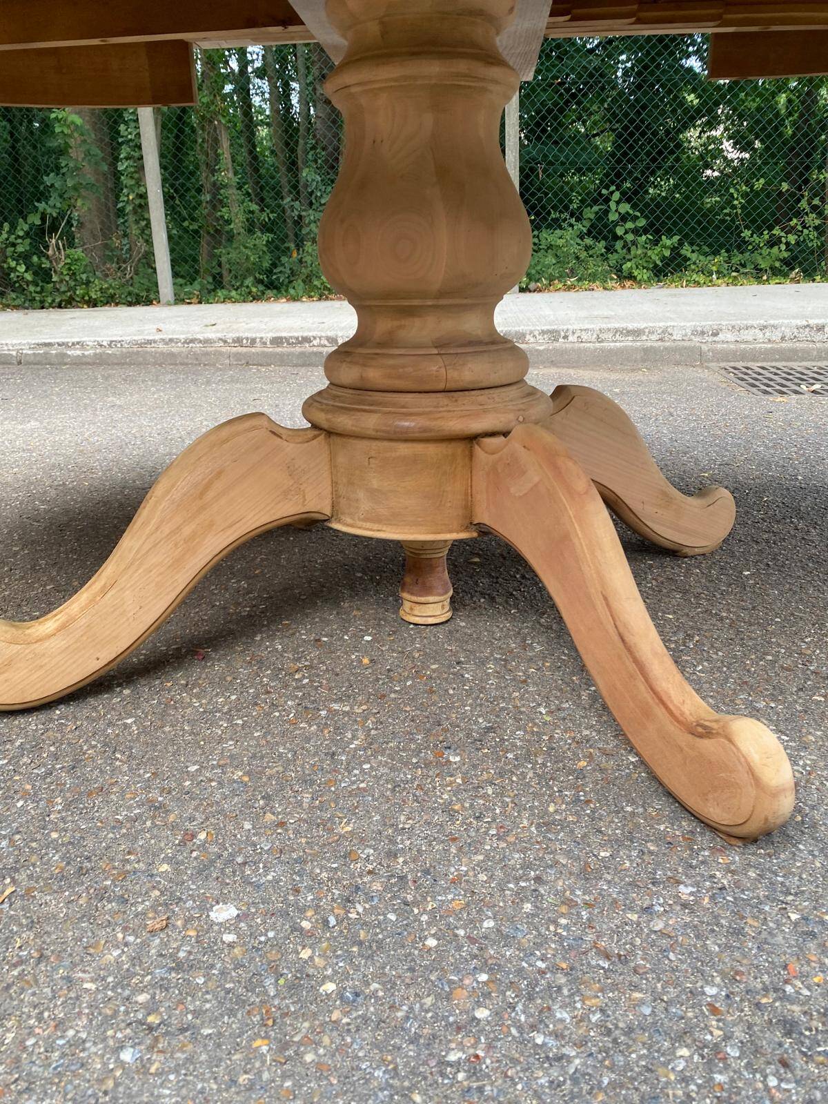 Round dining table with a central pedestal, extendable, stripped in solid walnut with 2 extensions.