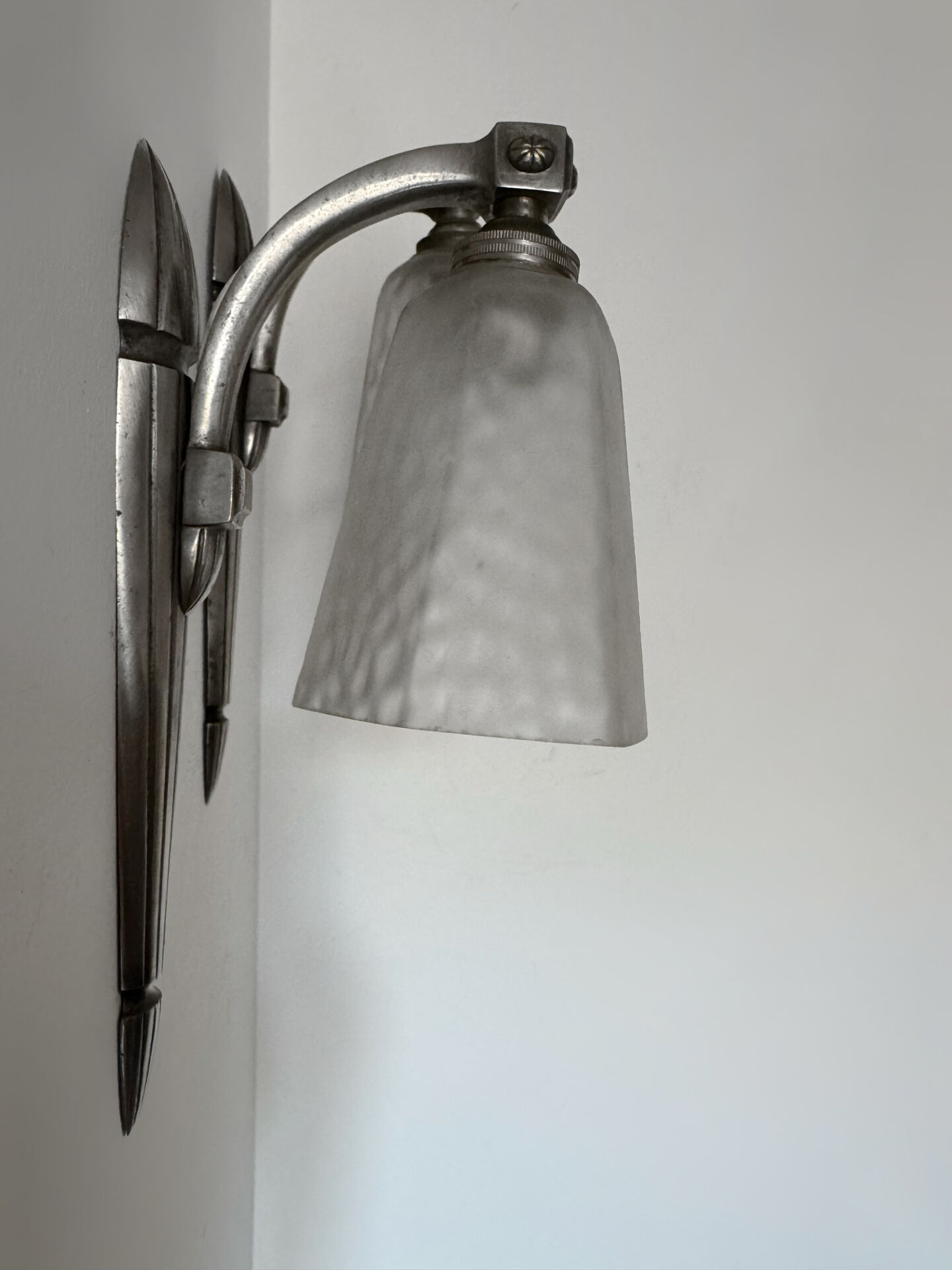 Silver Art Deco wall lights with frosted glass.