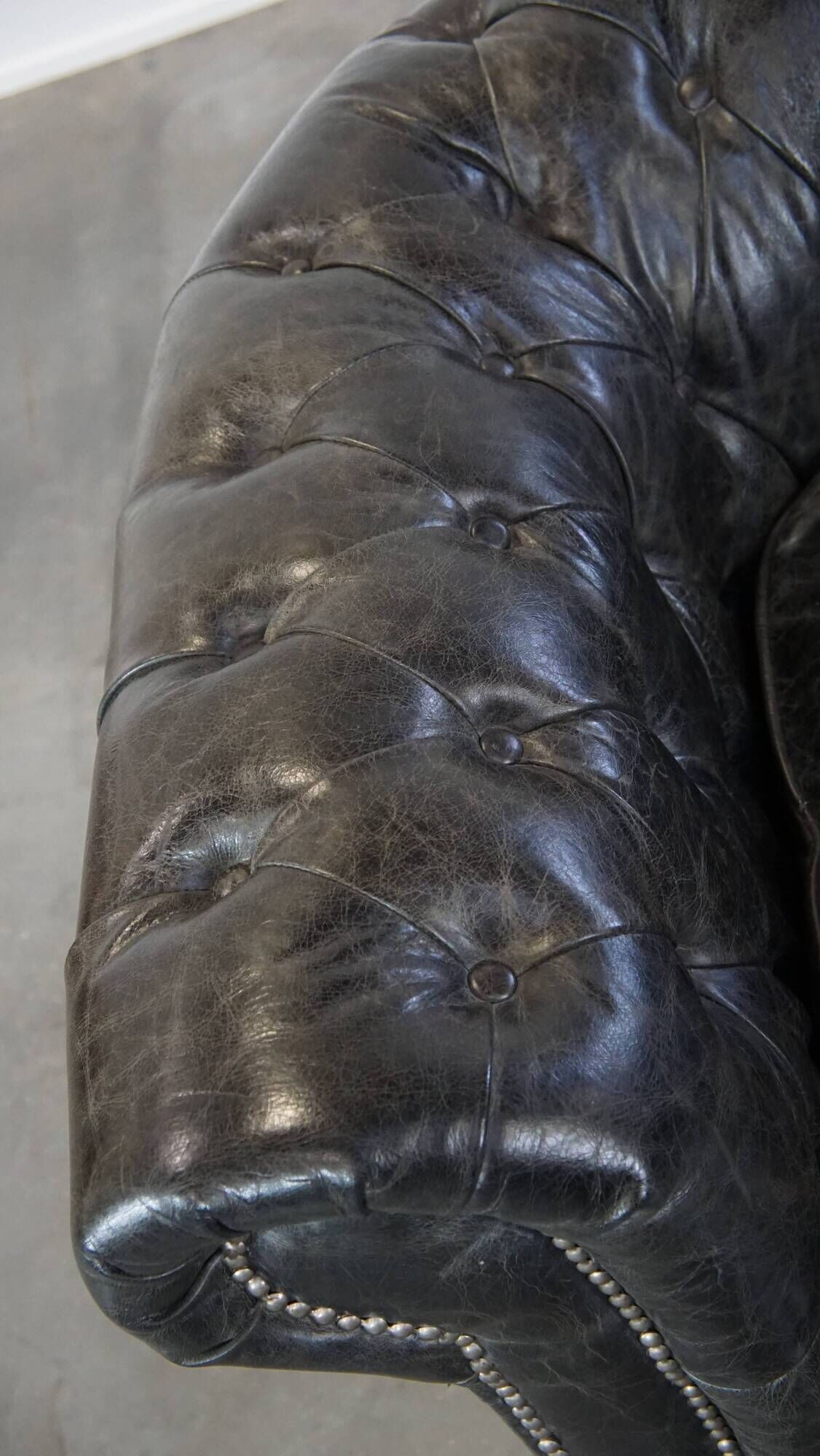 Spacious black cow leather chesterfield armchair with distinctive character
