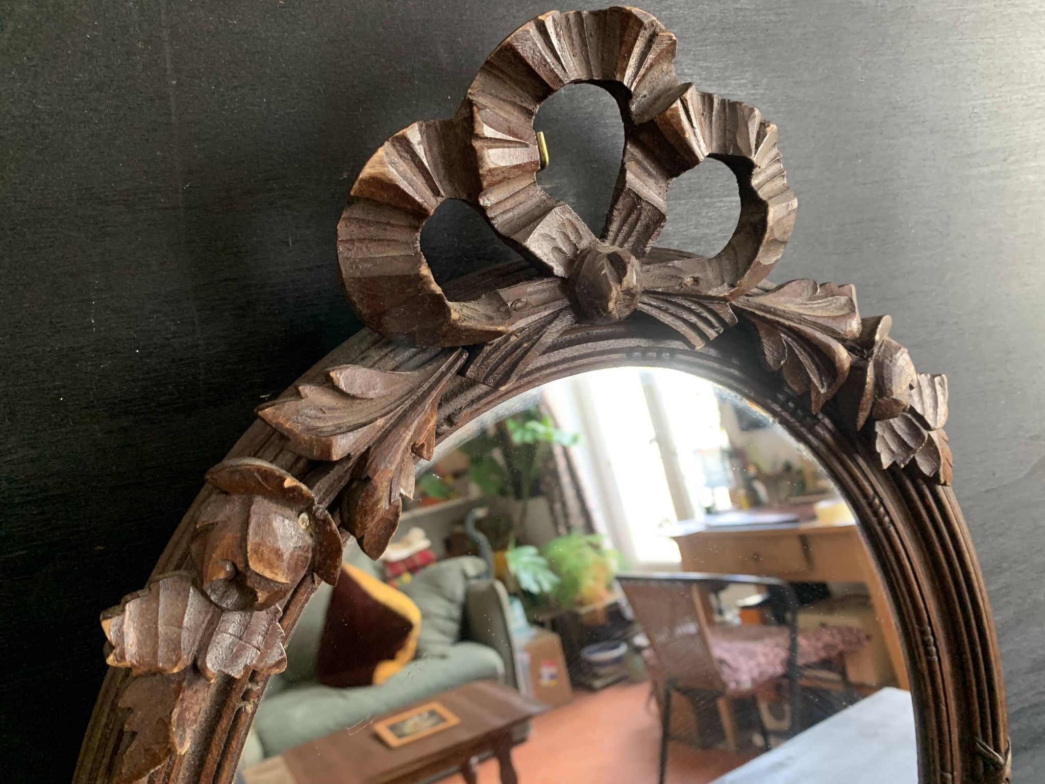 Antique oval mirror in carved wood and Louis XVI style knot