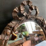 Antique oval mirror in carved wood and Louis XVI style knot