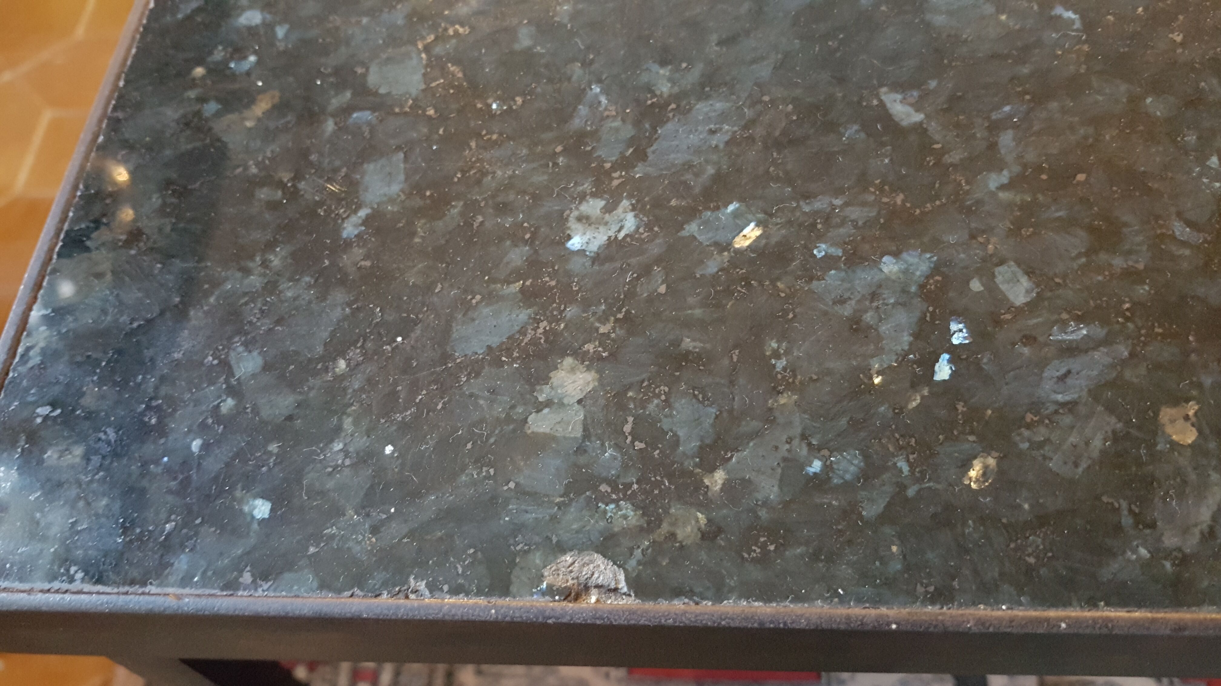 Coffee table with top in silver granite and welded steel base.