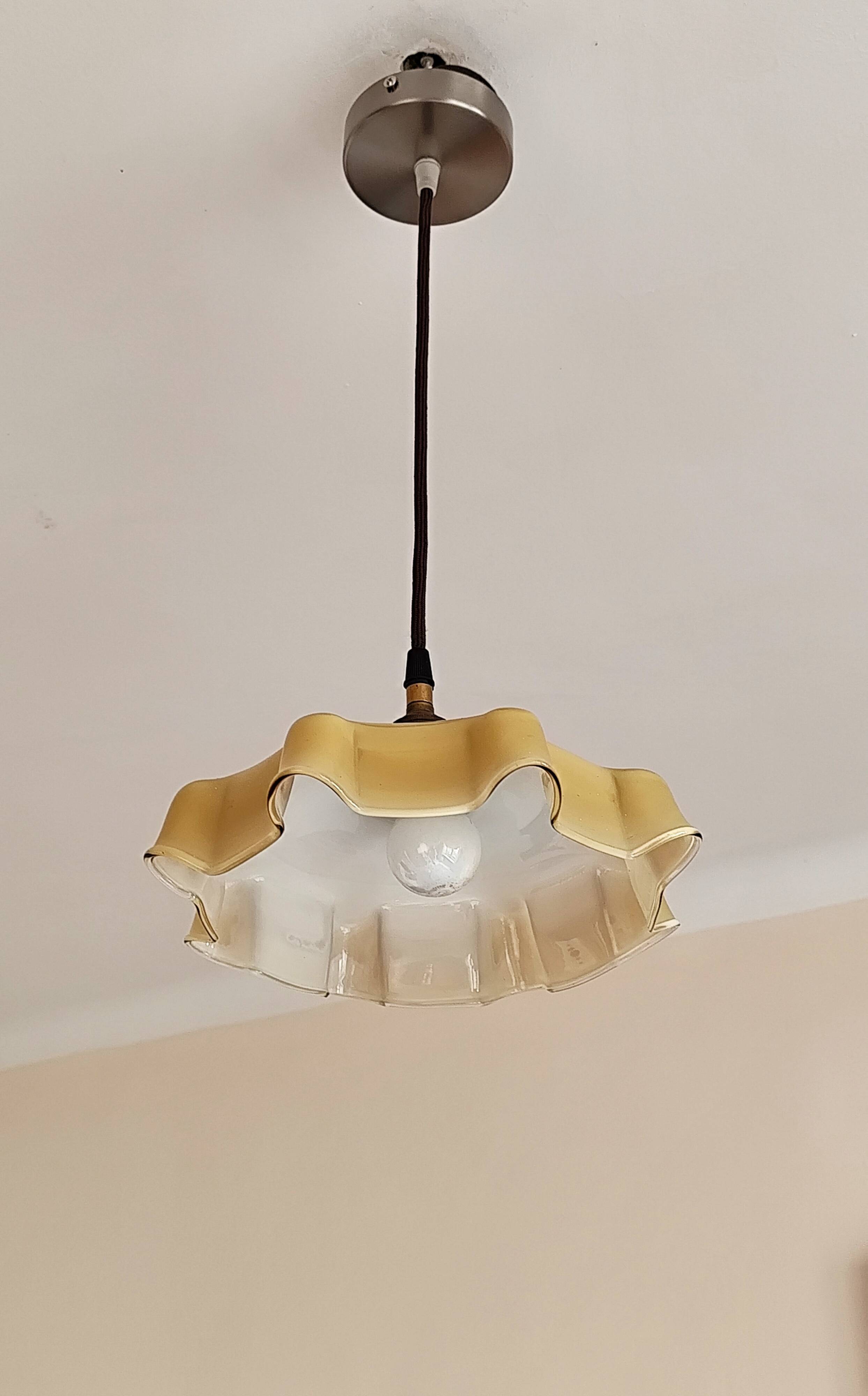 Electrified suspension with a frosted opaque glass disc shade.
