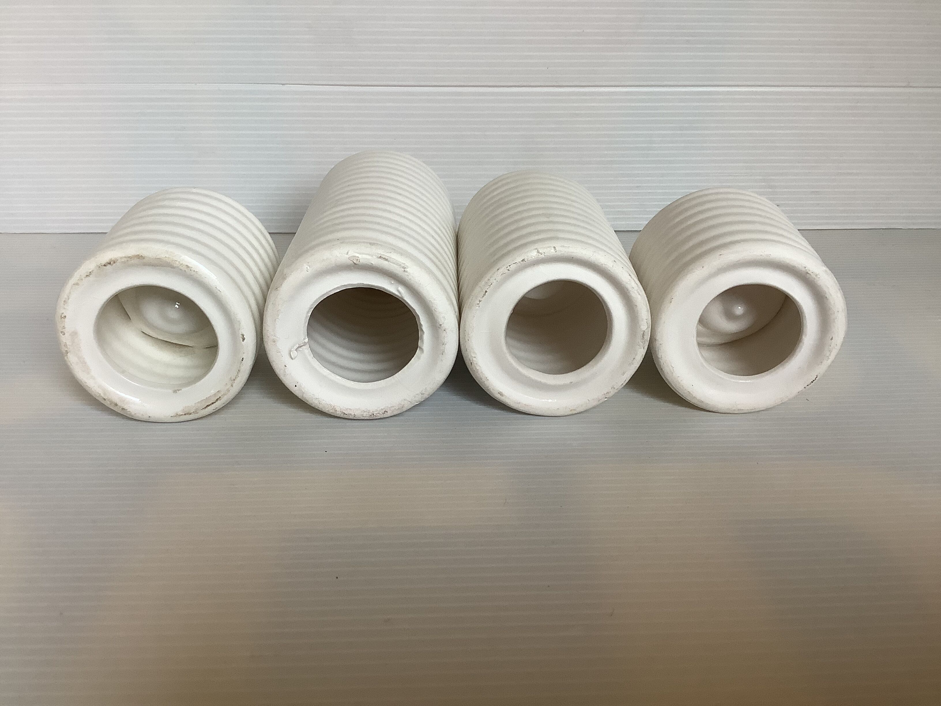 Four white earthenware candle holders