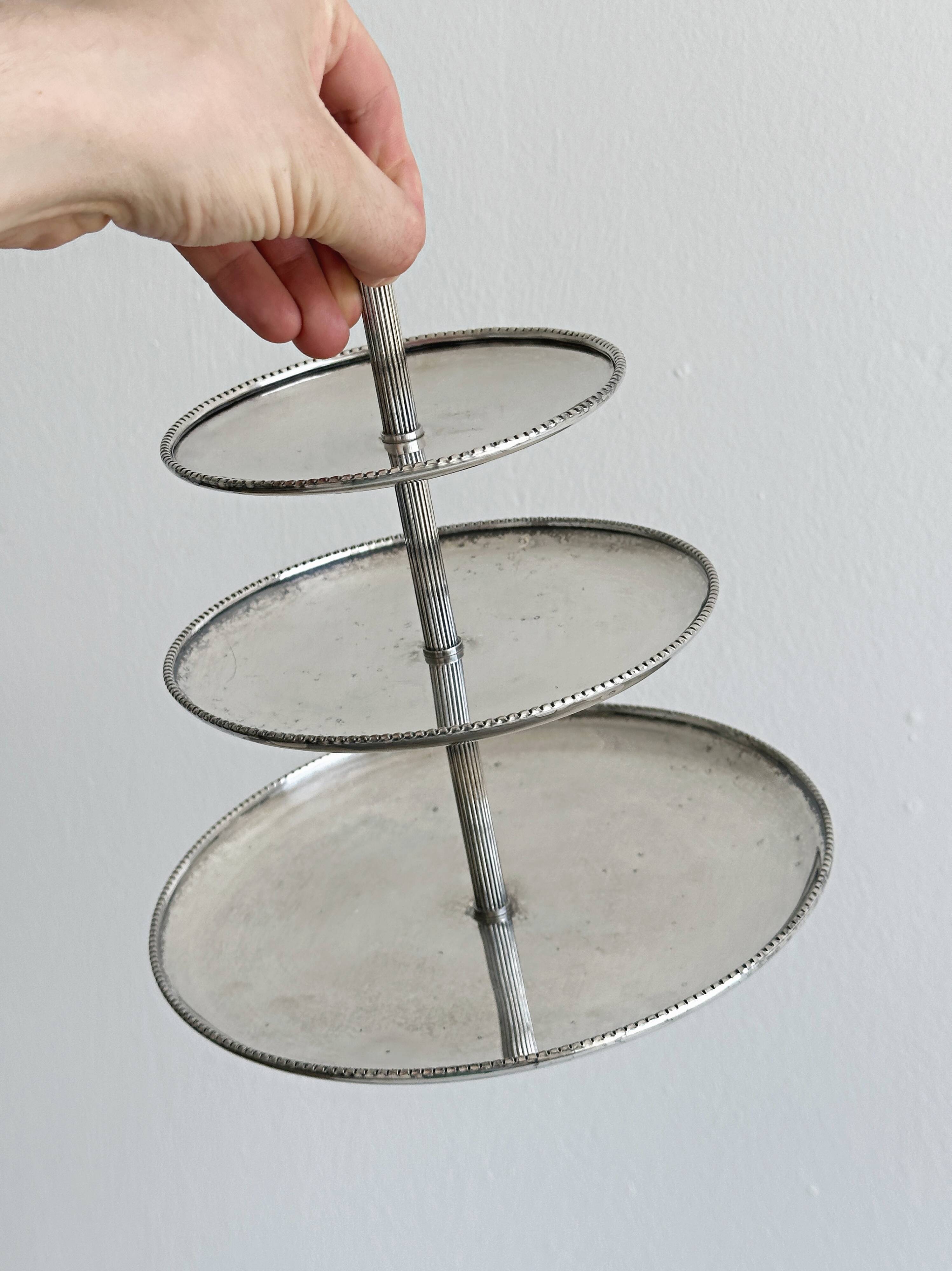 Vintage three-tiered serving stand in patinated silver metal.