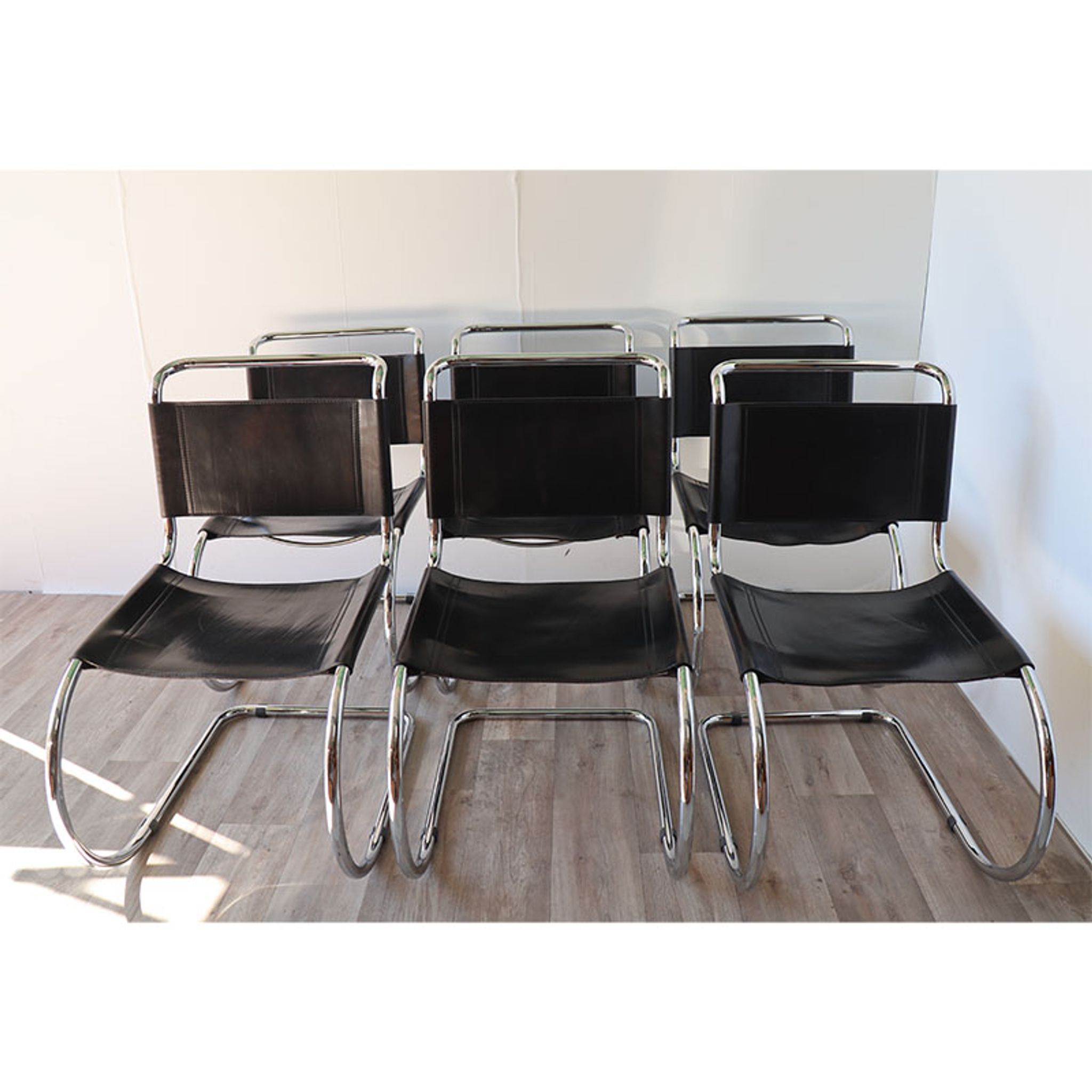 Series of 6 minimalist chairs in chrome metal and black leather around 1970
