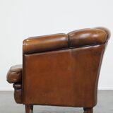 Unique vintage cognac-coloured leather club armchair with black piping