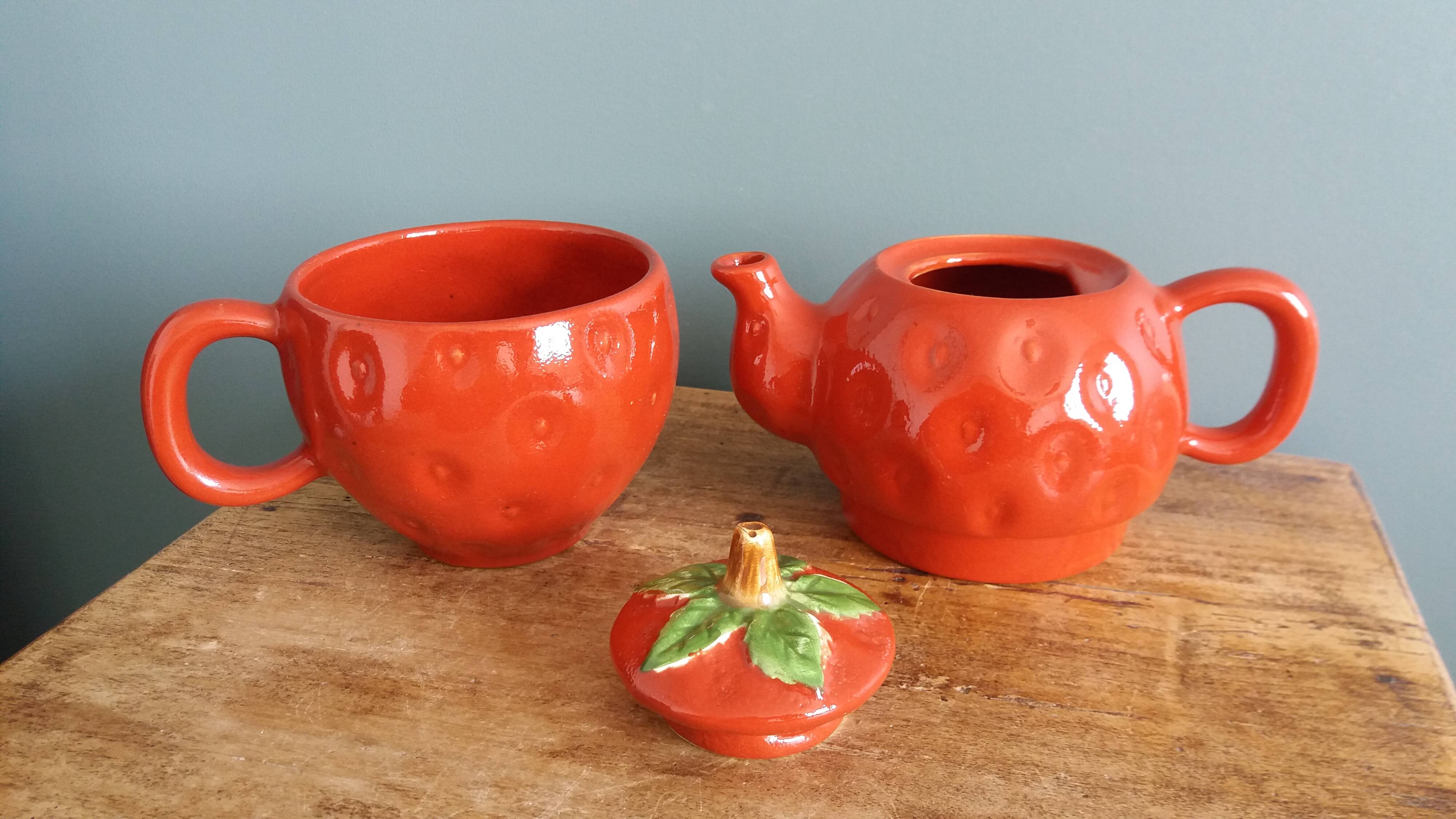 Teapot and cup in the shape of a strawberry.