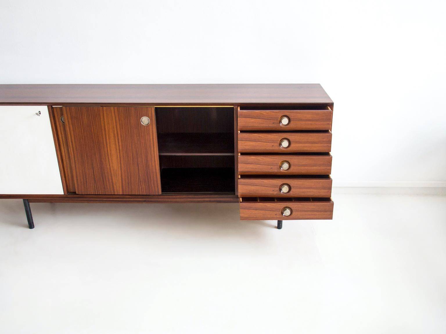 Wooden sideboard with sliding door and white drawers, around 1960.