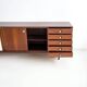 Wooden sideboard with sliding door and white drawers, around 1960.
