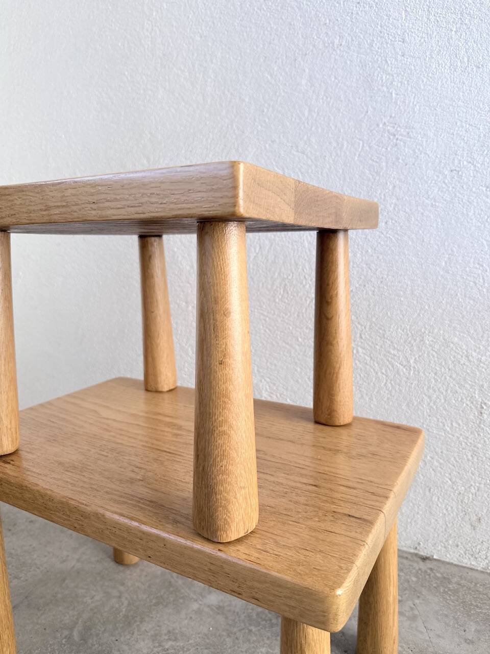 Two stools or small nesting tables in light oak.