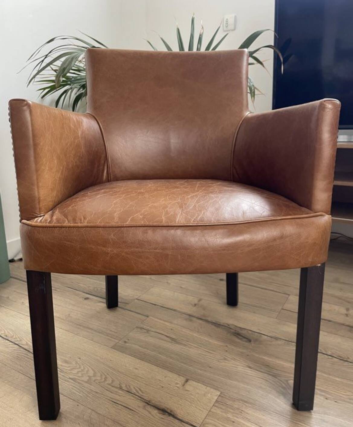 Chair with armrests in aged brown cowhide leather