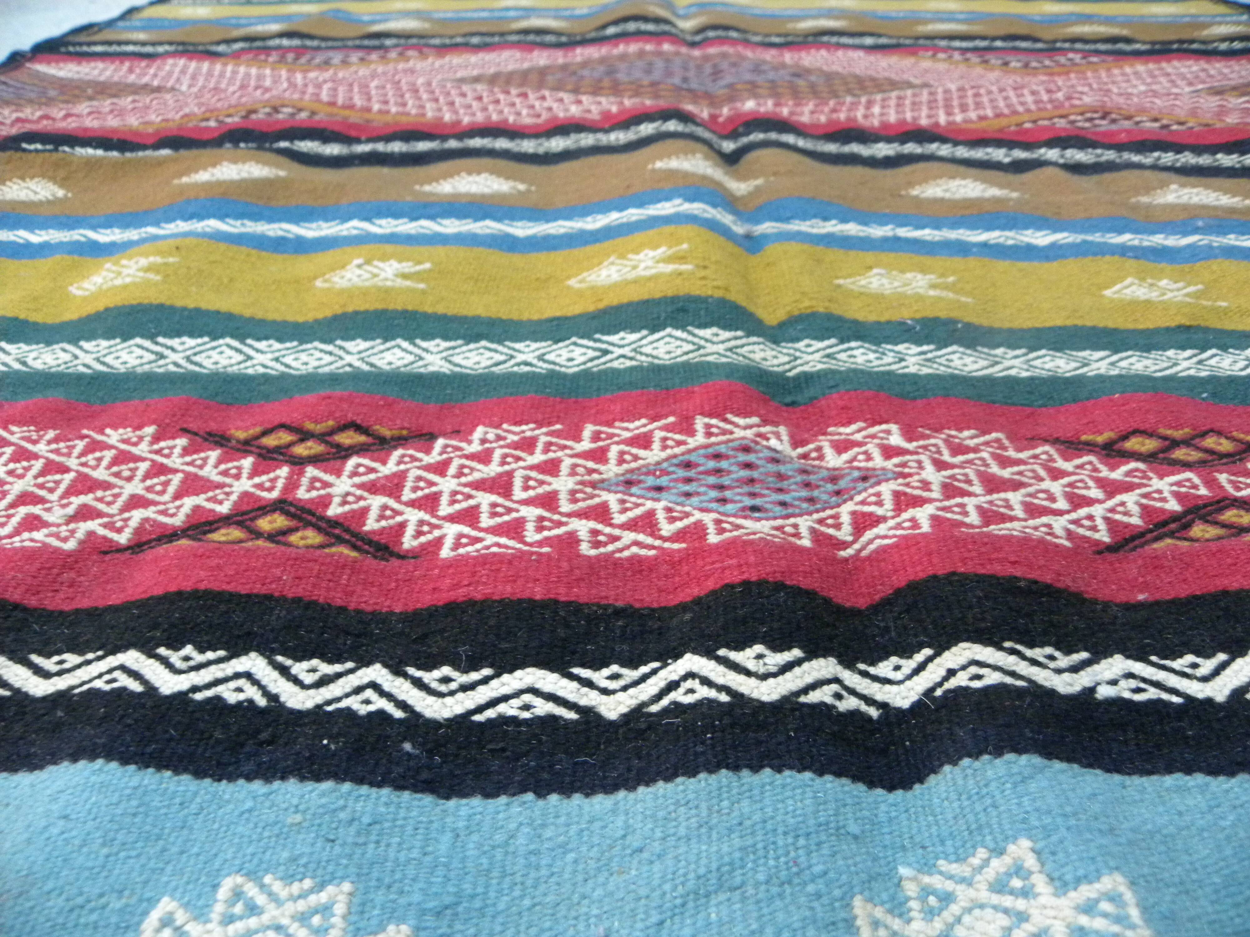 Traditional Berber tribal kilim rug with multicoloured geometric patterns.