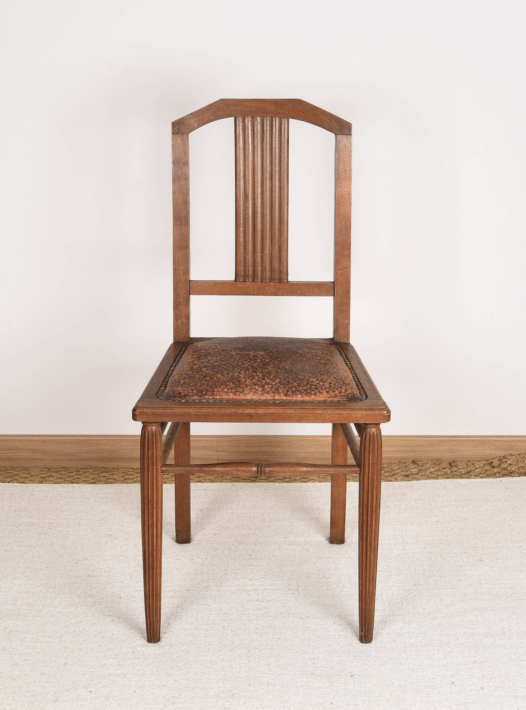 Art Deco style chair in carved wood and leather.