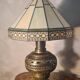 brass and bronze lamp with an antique base from 1900 and a glass paste shade