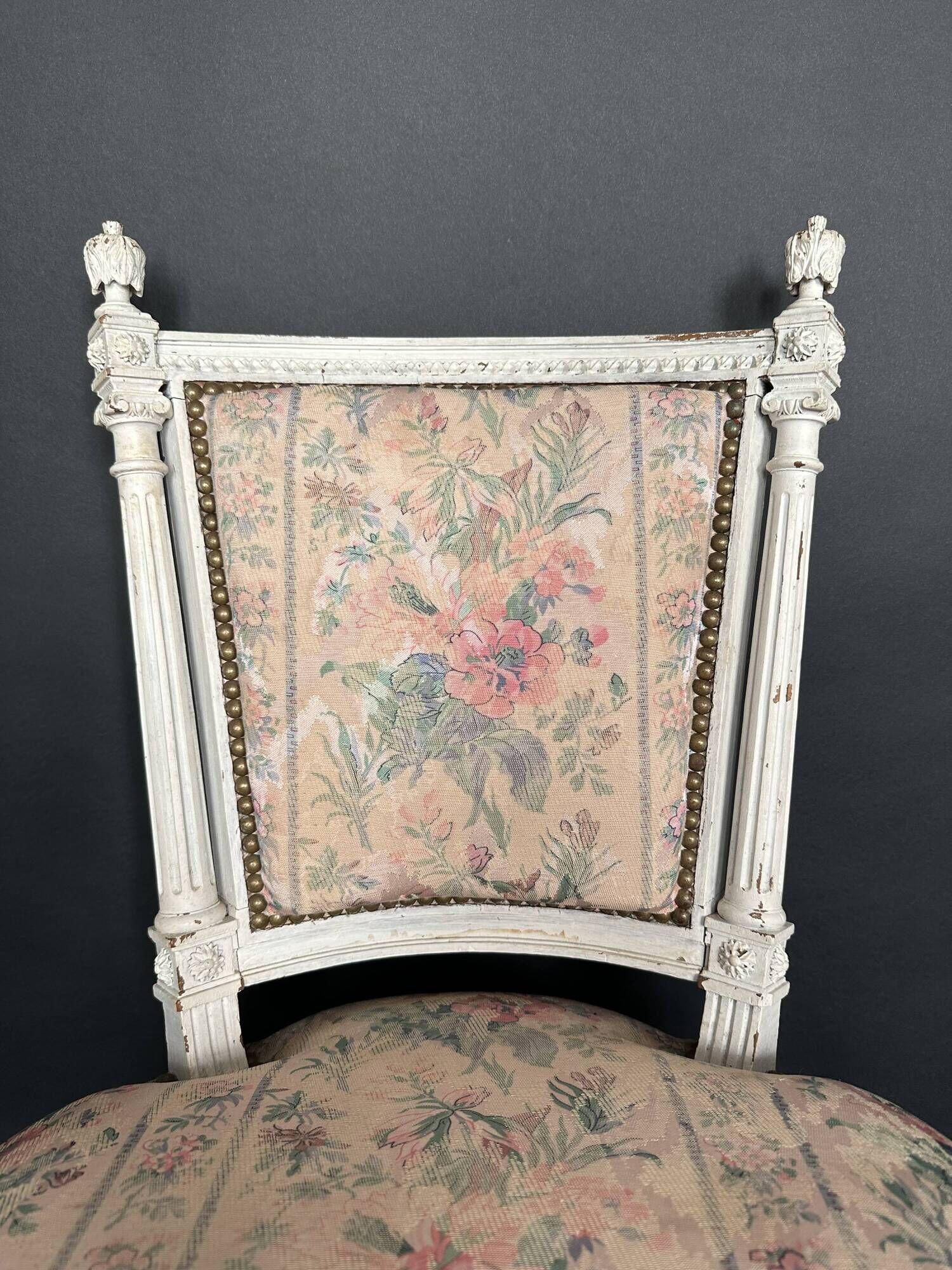 Antique Louis XVI style chair with patinated wood and floral fabric.