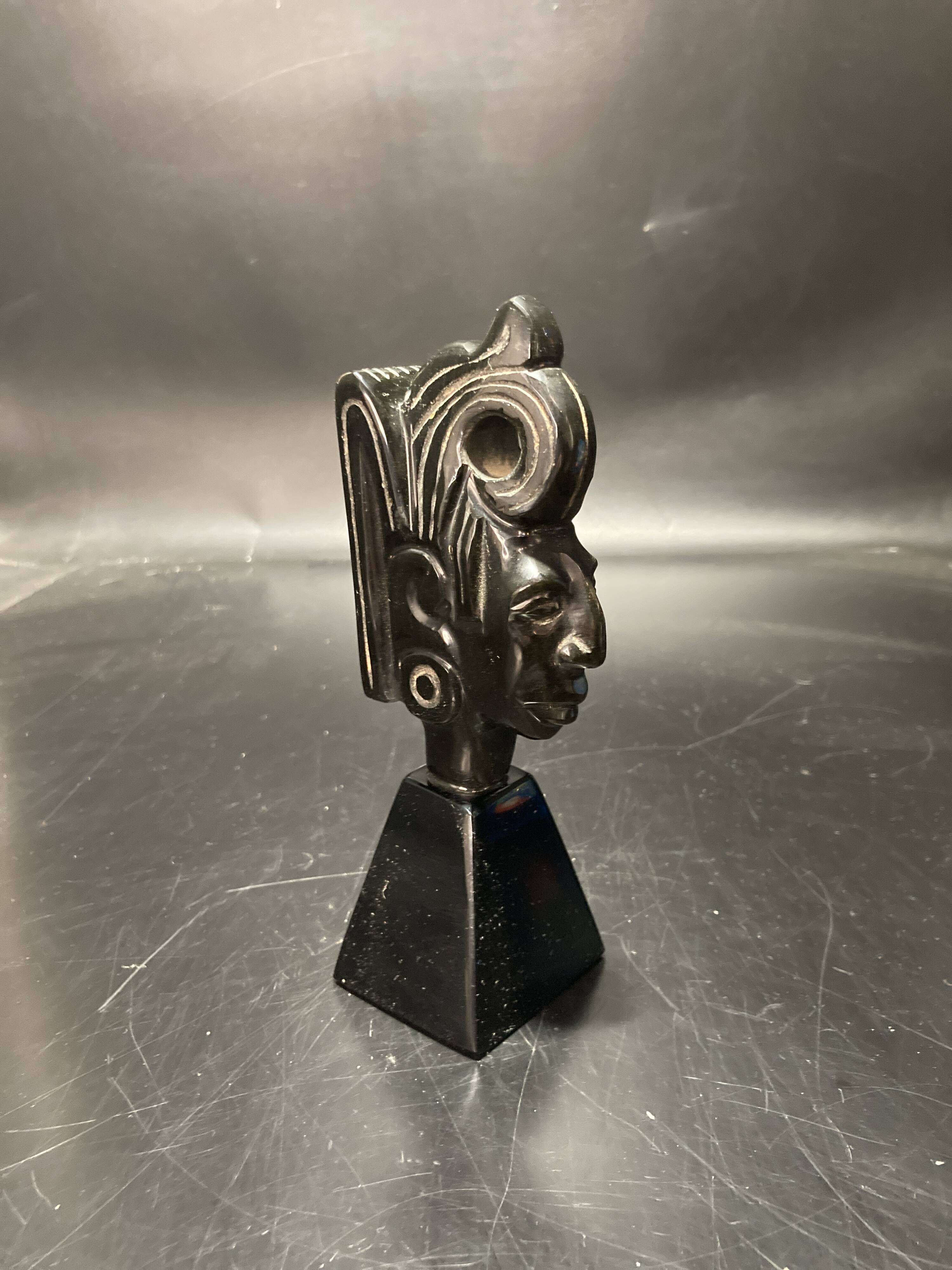 Ceramic sculpture representing a woman's face placed on a black base
