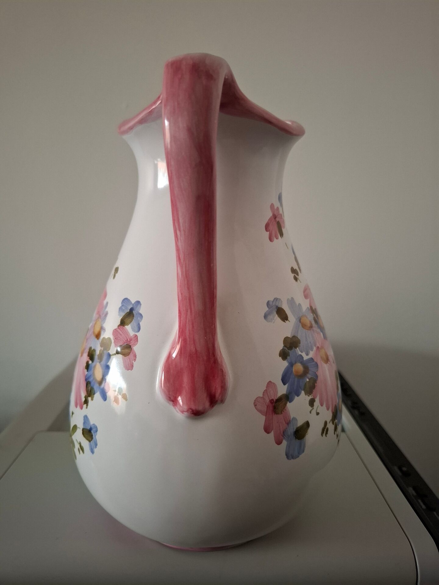 Old ceramic pitcher with floral decoration.