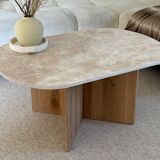 Oval coffee table in travertine and raw oak.