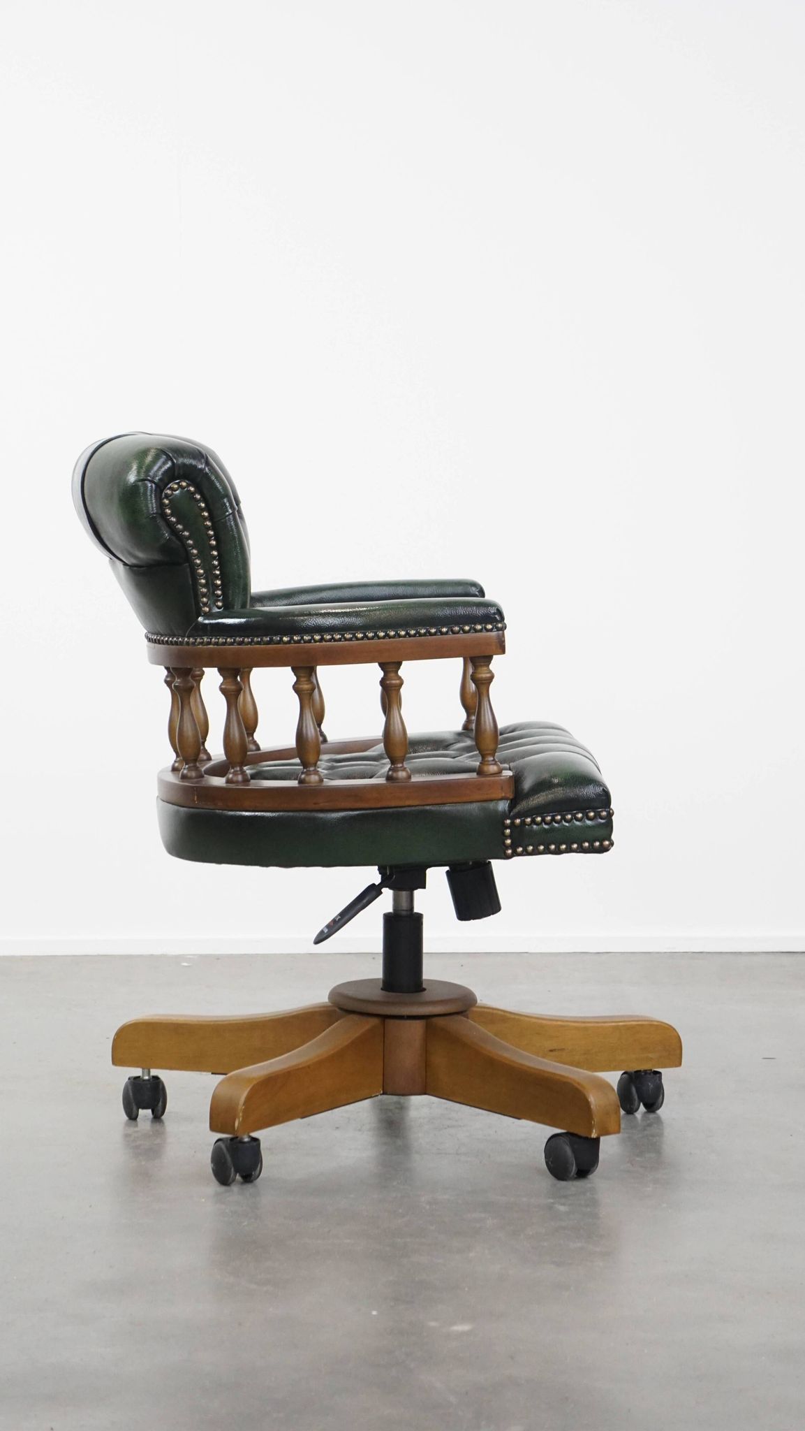 Dark green cowhide leather and wood chesterfield office chair on wheels