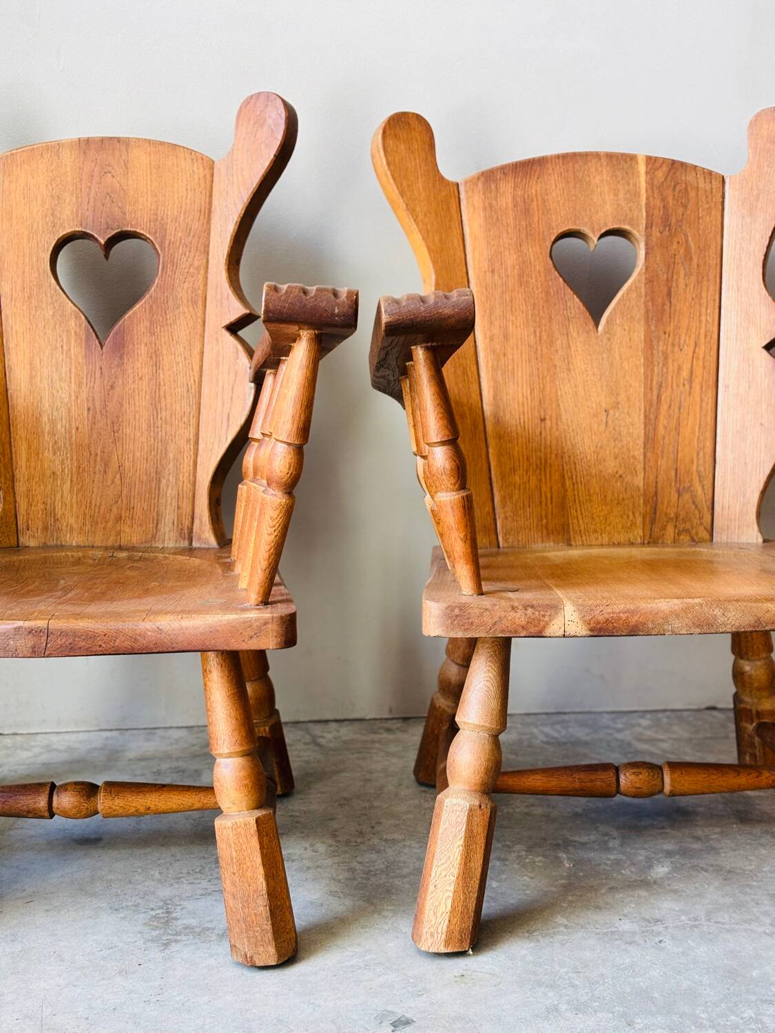 Pair of rustic oak armchairs – carved heart backrests