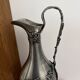 Ewer in pewter surrounded by vine branches with g