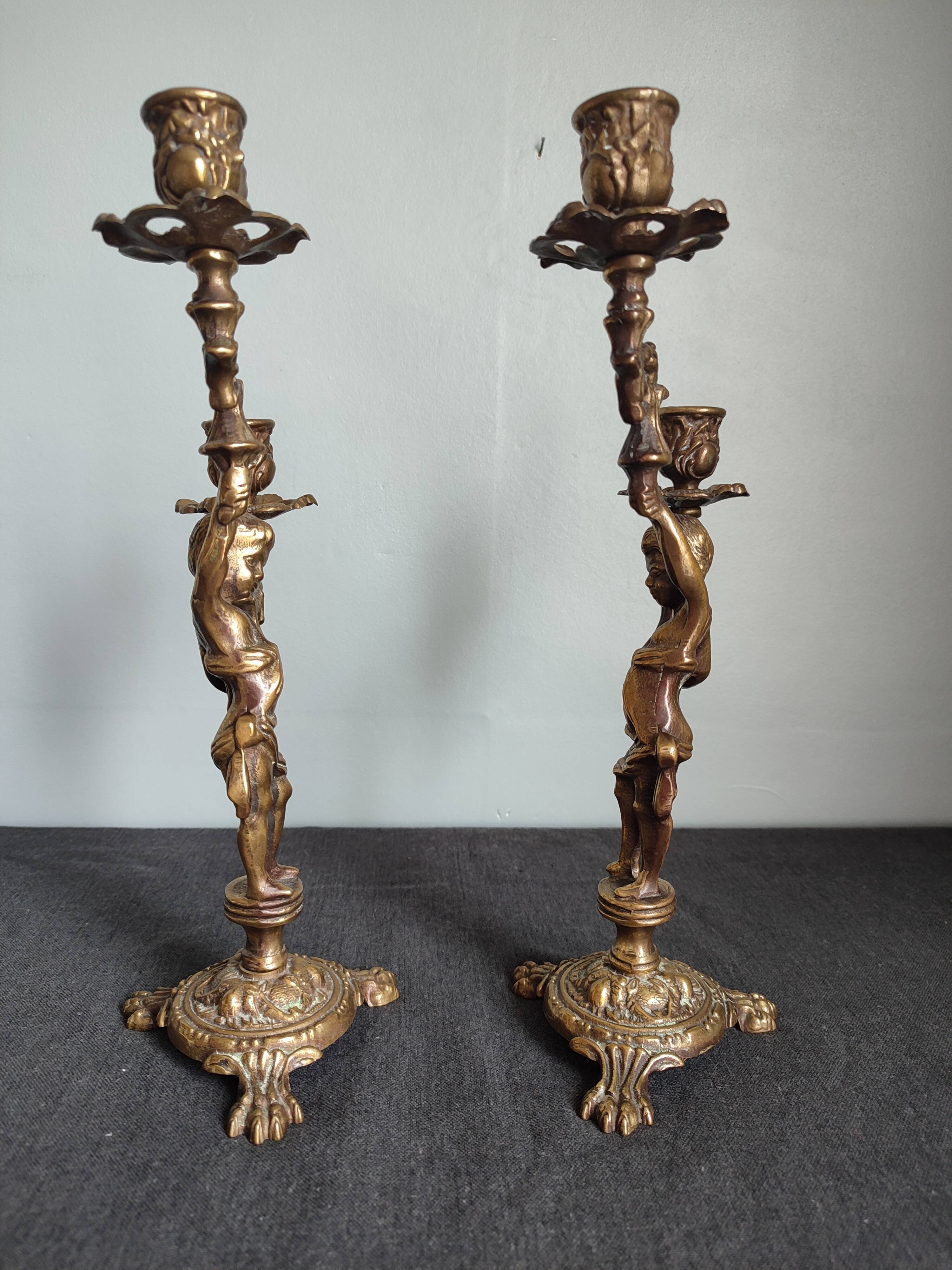 Pair of antique candlesticks in cherub bronze