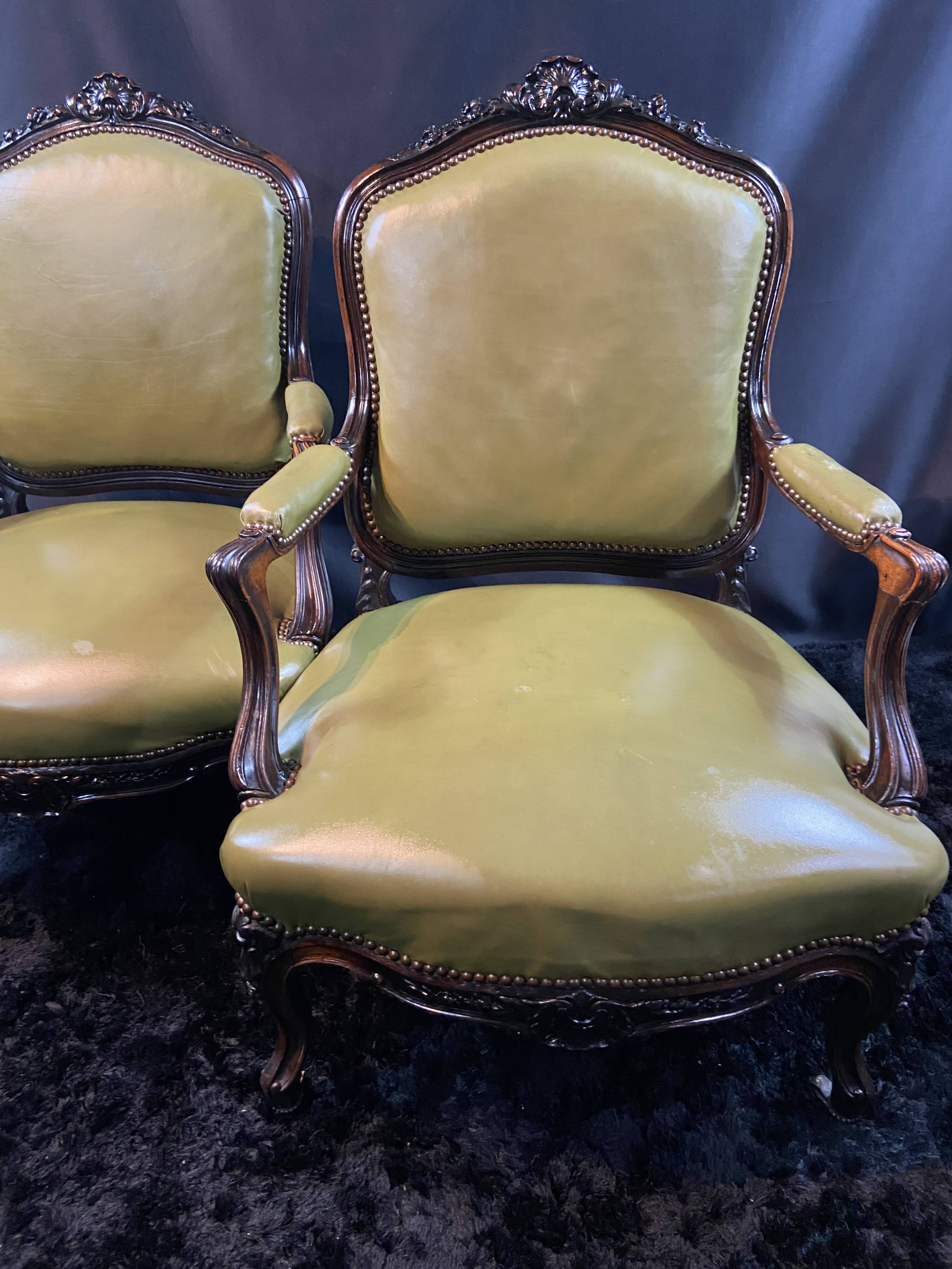 Paire de larges fauteuils XIXe en cuir vert de style Louis XV