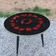 Vintage coffee table with glass top and tripod legs in blackened wood from the 1960s.