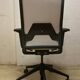 Office chair with wheels and mesh backrest.