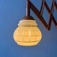 Vintage wall lamp with teak wood scissors and glass shade.